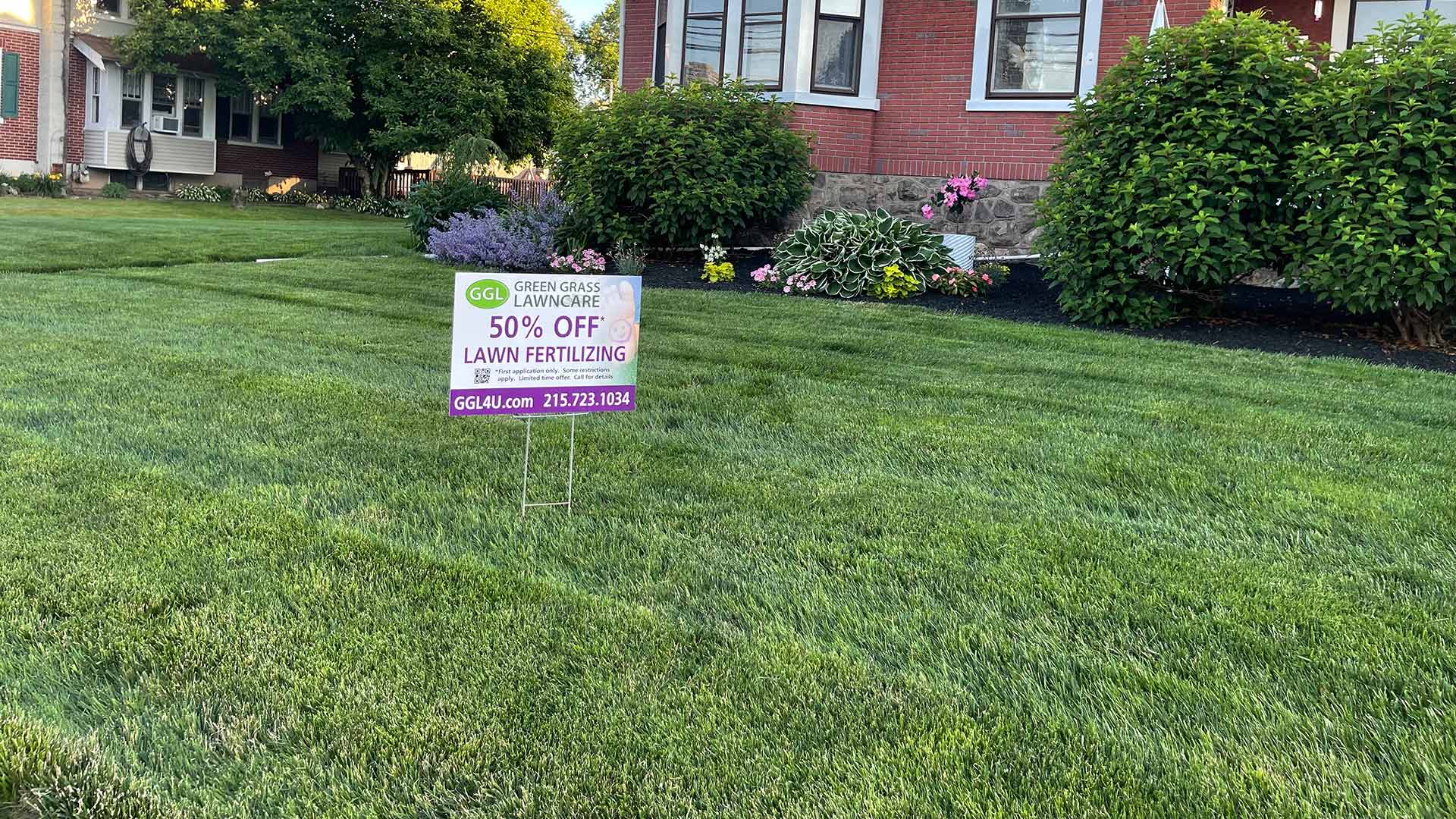 A yard in Norristown, PA with lush green grass and a yard sign.