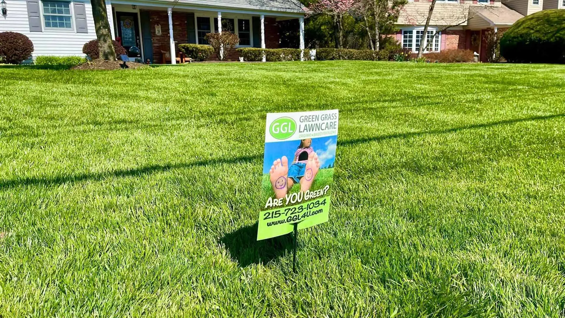 Thick, lush green grass in a yard with a lawn care sign near Telford, PA.