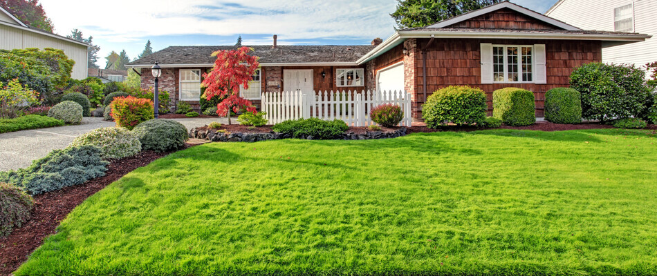 A wood sided home with a healthy green lawn surrounded by landscaping in Red Hill, PA.