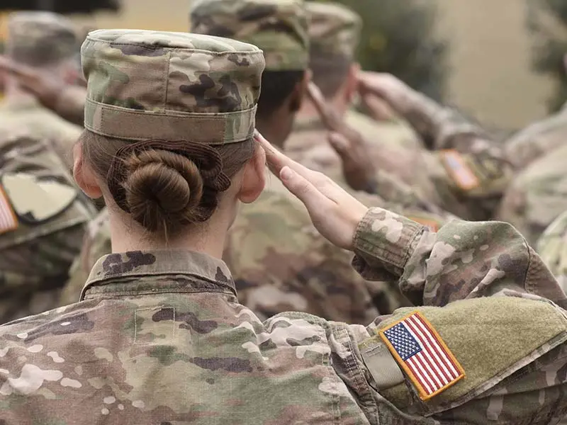 U.S. military soldiers in formation while saluting.