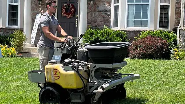 Lawn care technician fertilizing a yard near Souderton, PA.