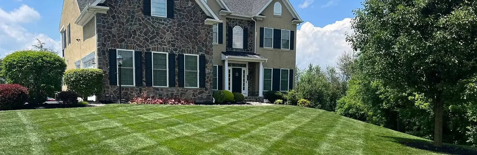 natural stone home with green lawn
