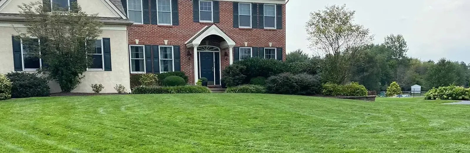 large brick home with healthy thick green grass